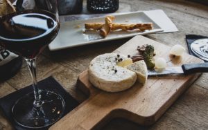 Fromage sur planche avec un verre de vin rouge